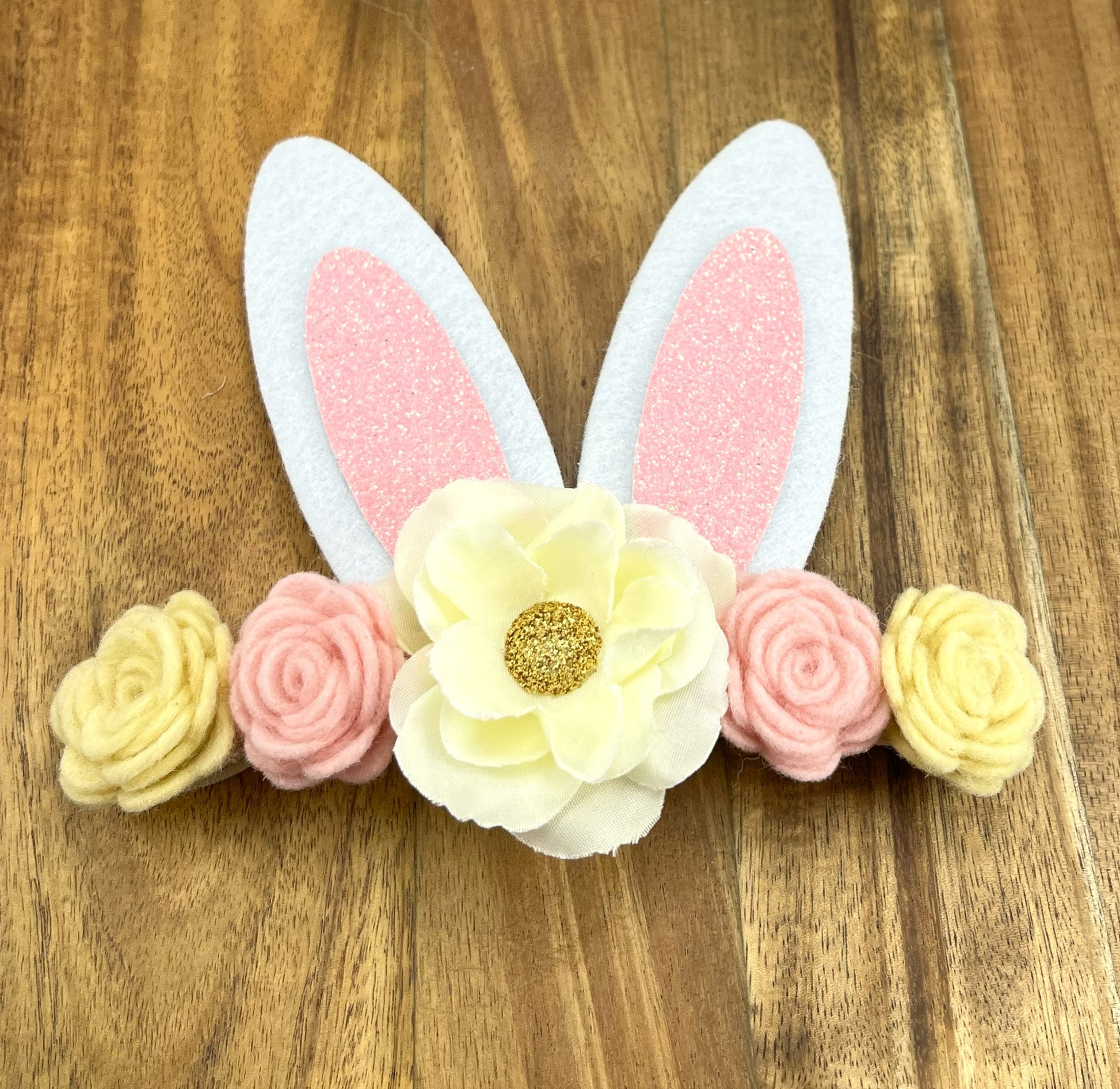 Bunny ears headband with pink and yellow flowers on a wooden background