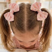 Child with pink hair bows in pigtails