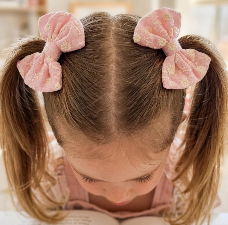 Child with pink hair bows in pigtails